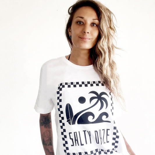 Front view of white T-shirt with ‘Salty Daze’ text and checker-outlined beach graphics, worn by female model.