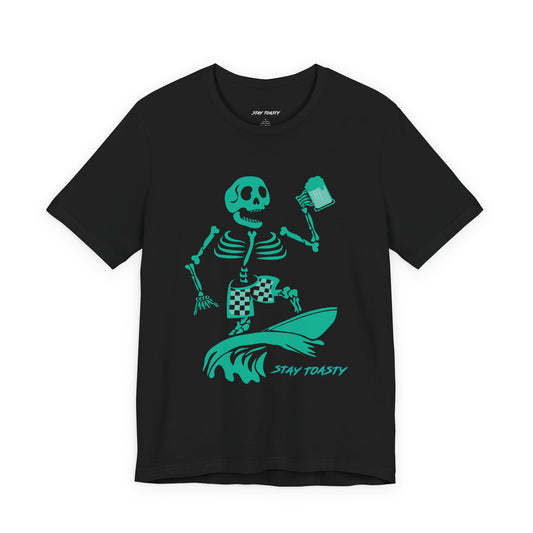 Black graphic tee with skeleton surfing a wave with checkered board shorts holding a beer. Stay Toasty logo under the wave. Front View.