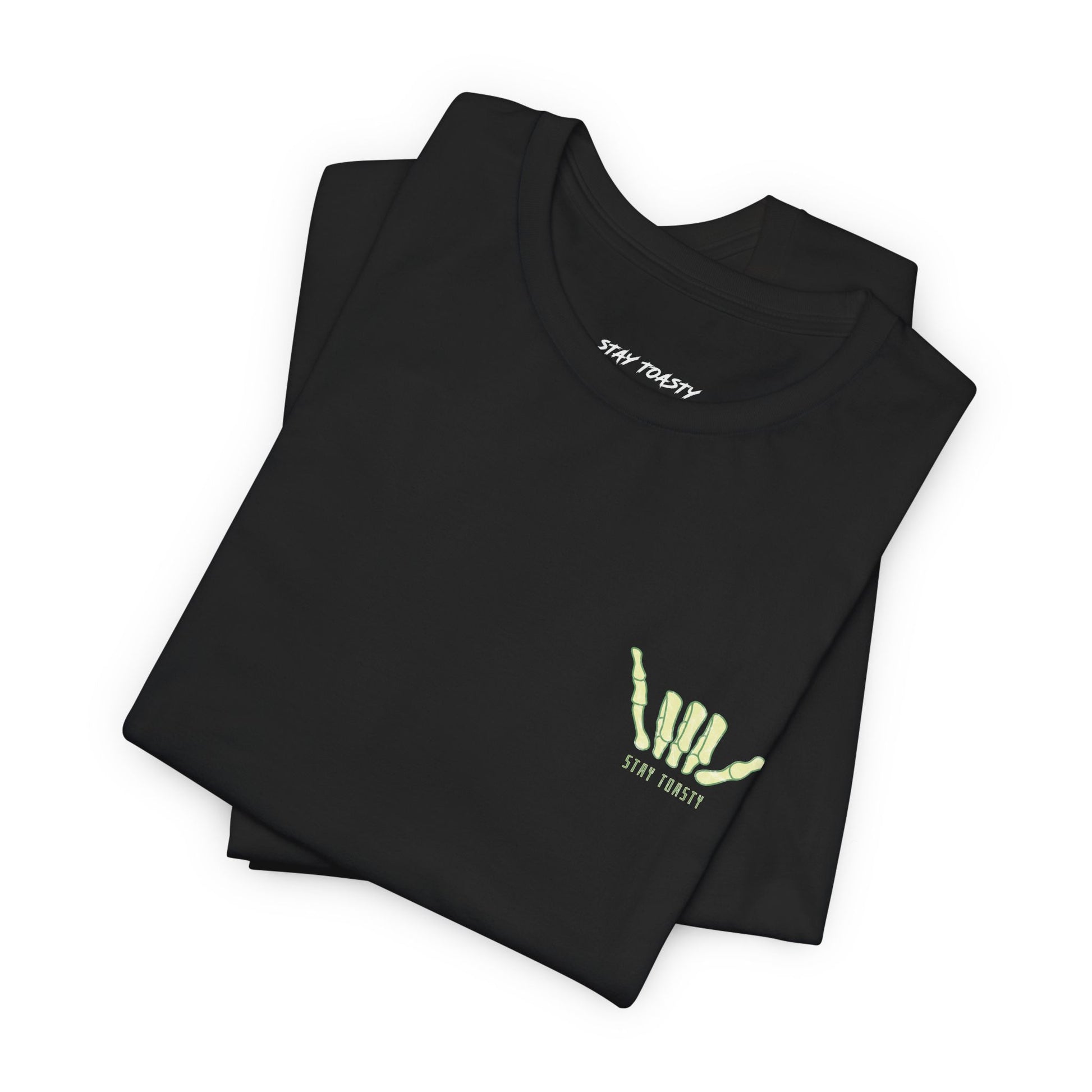 Black tee with front chest graphic of a skeleton hand shaka. Folded front view.
