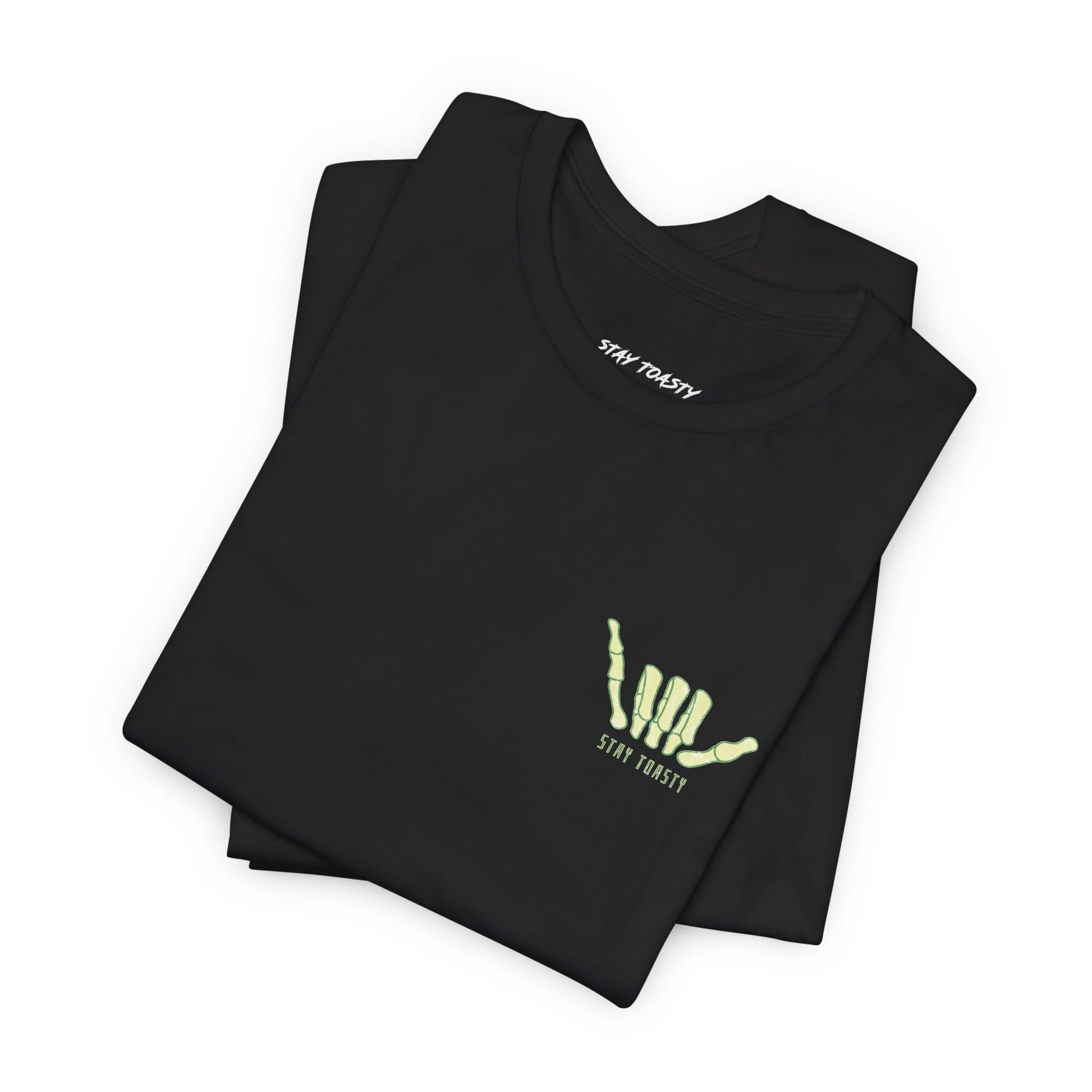 Folded black t-shirt with a yellow skeleton shaka on front chest