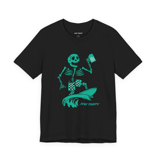 A black graphic tee featuring a green graphic of a skeleton surfing on a wave with a beer and the text 'STAY TOASTY' printed below.