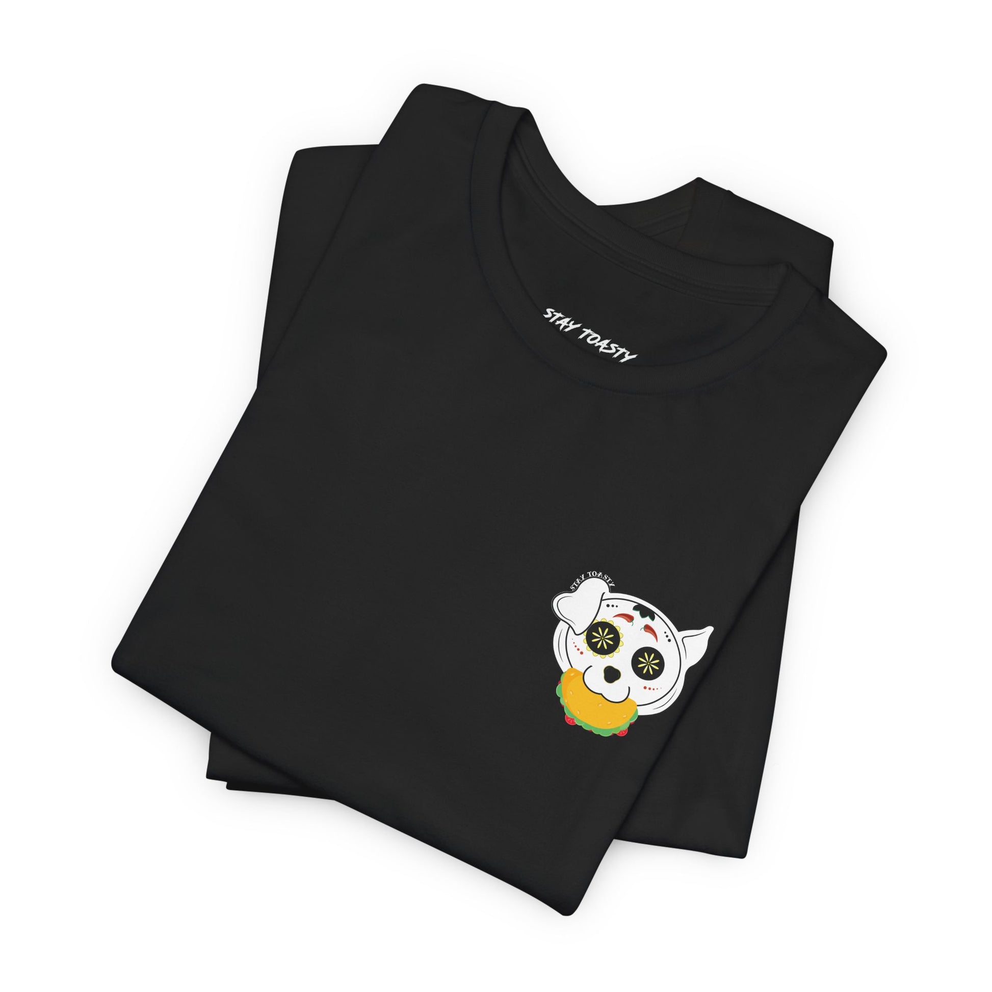 Black graphic tee with front chest design of sugar skull dog holding a taco. Front folded view.