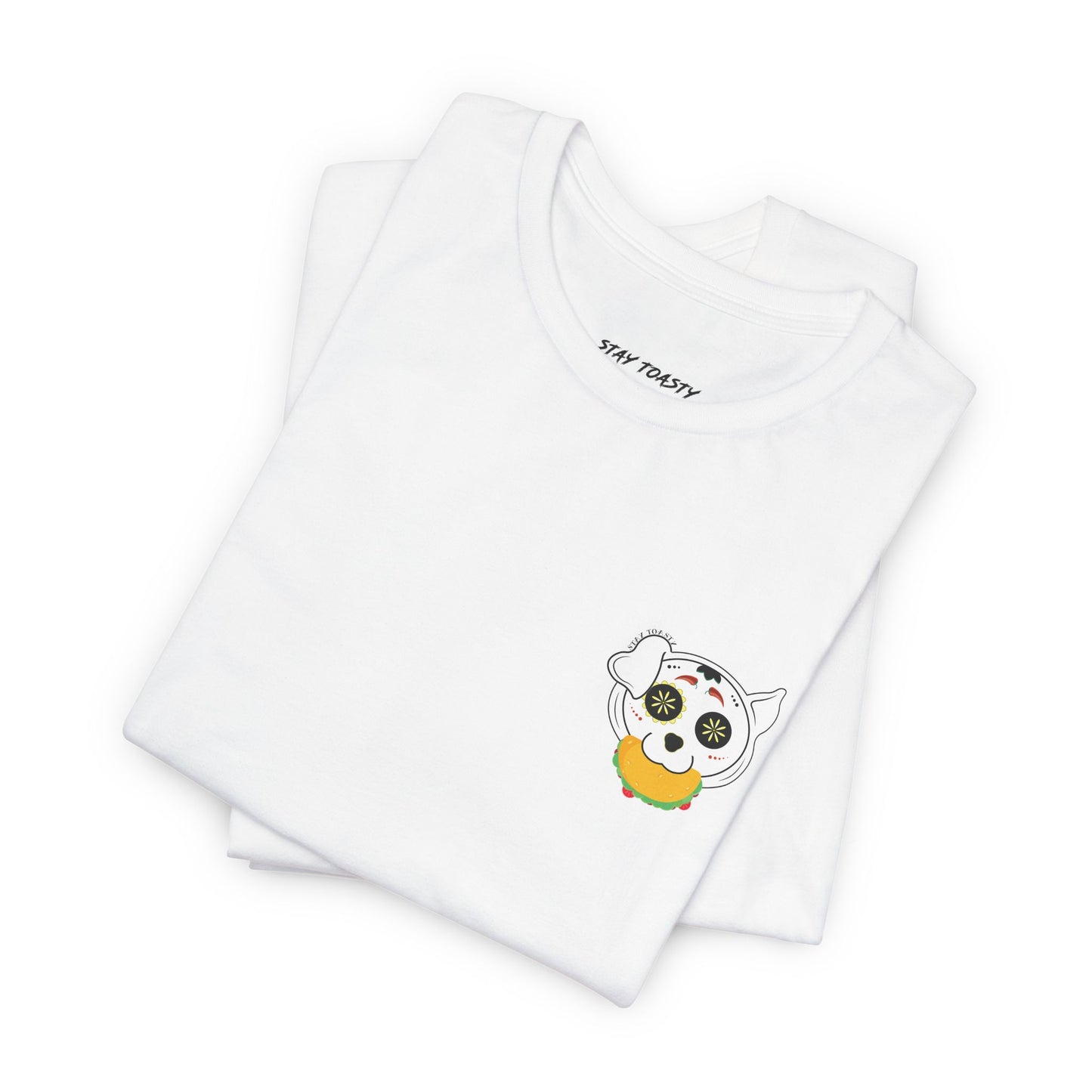 White graphic tee with front chest design of sugar skull dog holding a taco. Front folded view.