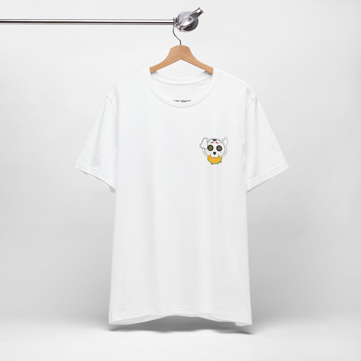 White graphic tee with front chest design of sugar skull dog holding a taco. Front hanging view.