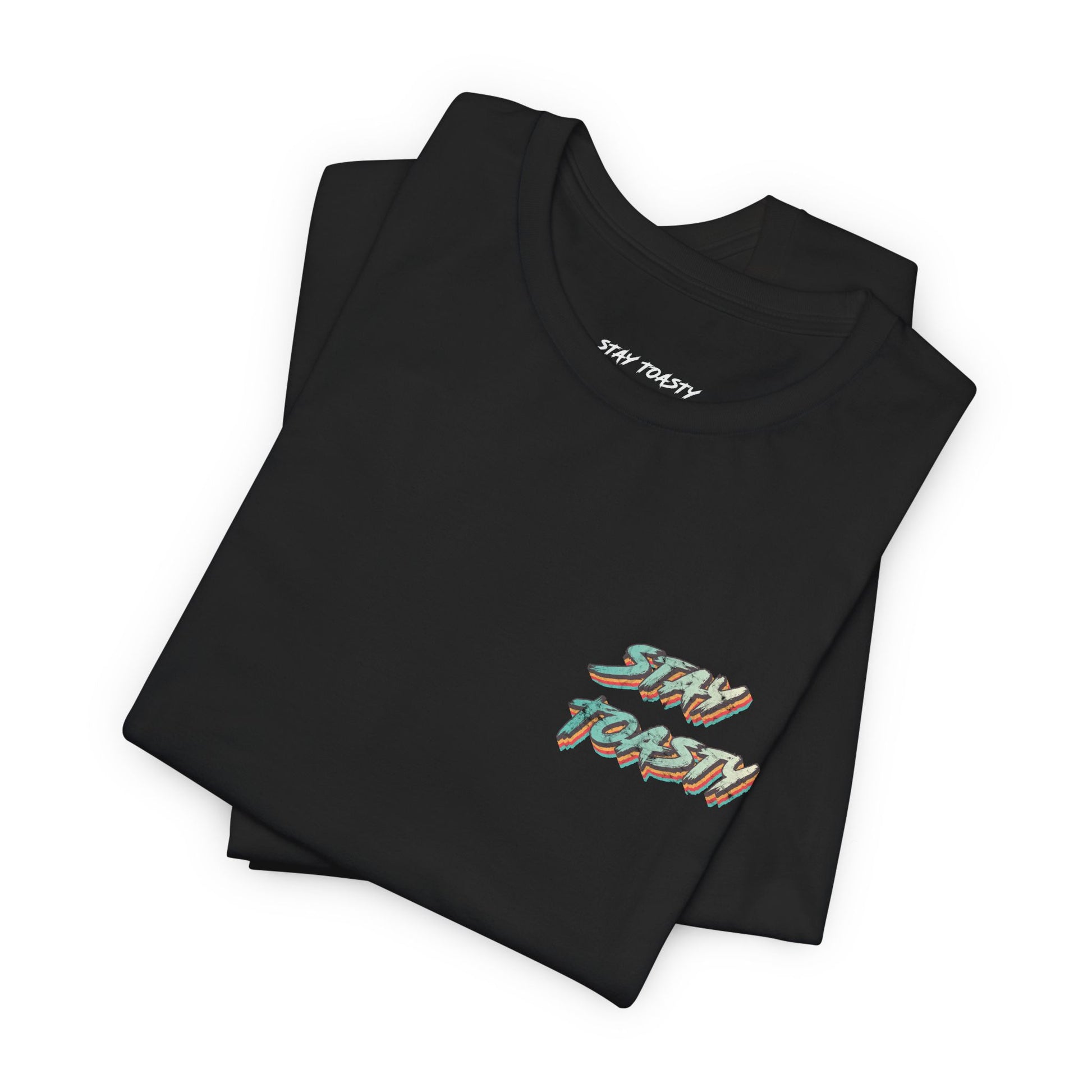 Folded black graphic tee with vintage/retro text 'STAY TOASTY" on front chest. 