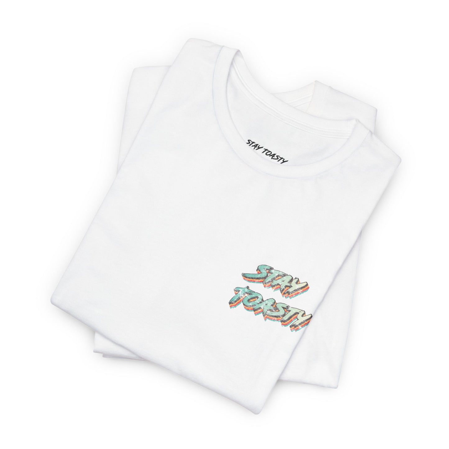 Folded white graphic tee with vintage/retro text 'STAY TOASTY" on front chest. 