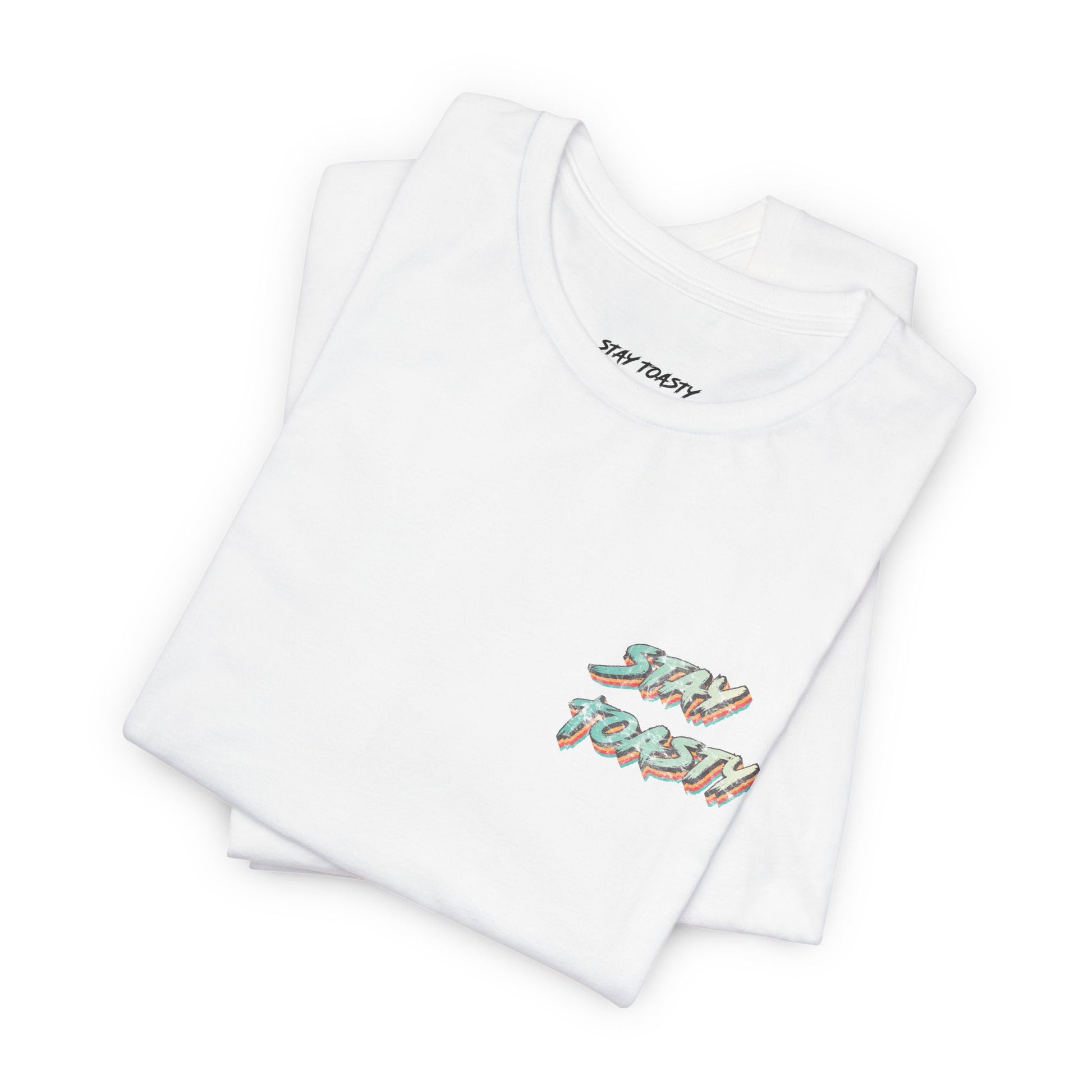 Folded white graphic tee with vintage/retro text 'STAY TOASTY" on front chest. 